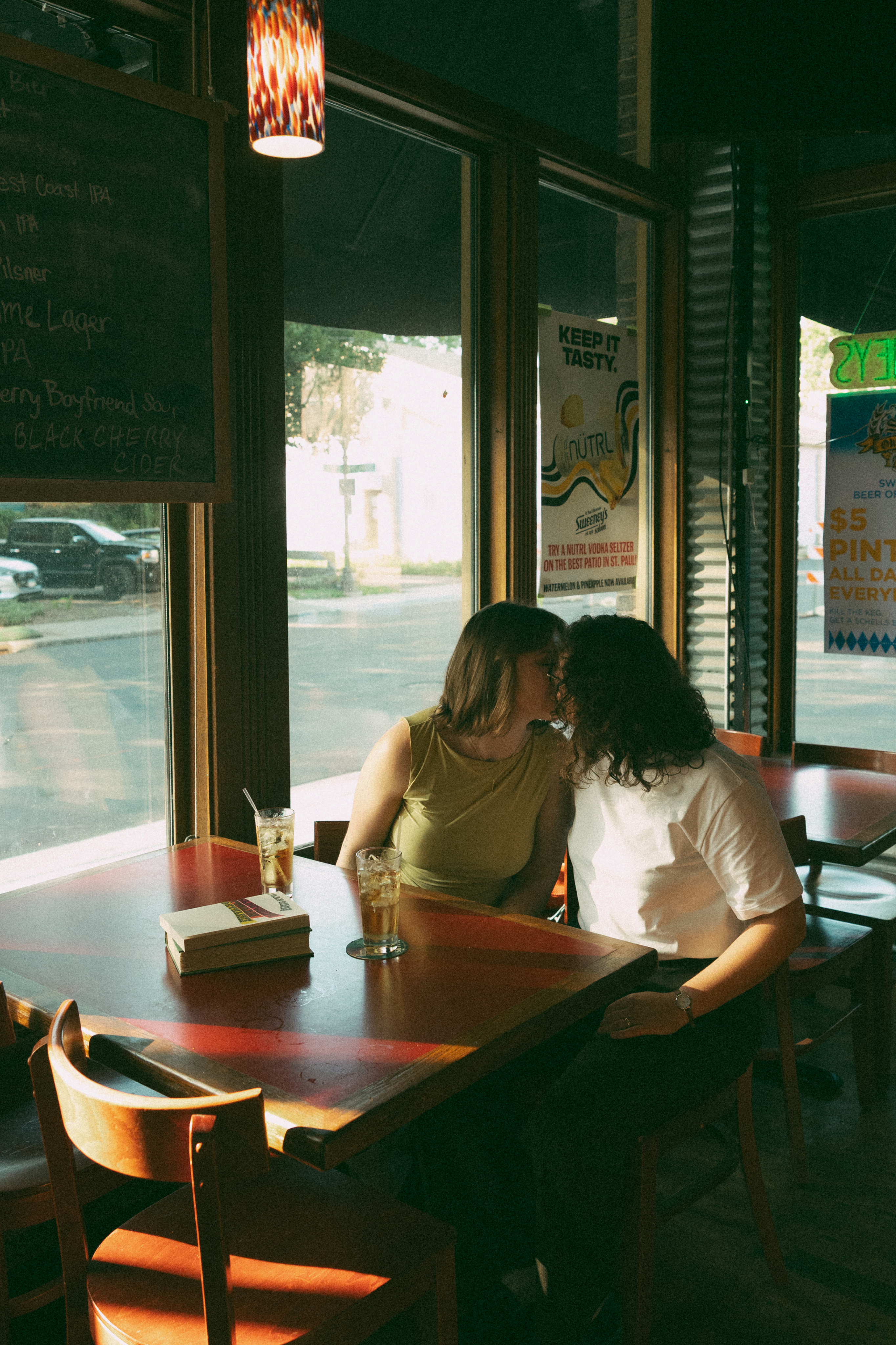 Polaroid photo of a couple posing together on a bed with the date 06/10/19 written on the polaroid.